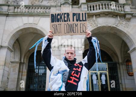 Hannover, Germania. 27 Feb 2021. Il modello Jonas Hagenow presenta una creazione di maglione da parte dello studente di moda Carolin Habermann di fronte al nuovo Municipio. La campagna di moda 'Dicke Pullis' (spessi maglioni) dell'Università di Scienze applicate e Arti di Hannover in collaborazione con il capitale dello Stato promuove una maggiore protezione del clima e il risparmio energetico nelle famiglie private. L'idea originale del 'Thick Sweater Day' belga è quella di abbassare di un grado il riscaldamento e indossare invece un maglione spesso. Credit: OLE Spata/dpa/Alamy Live News Foto Stock