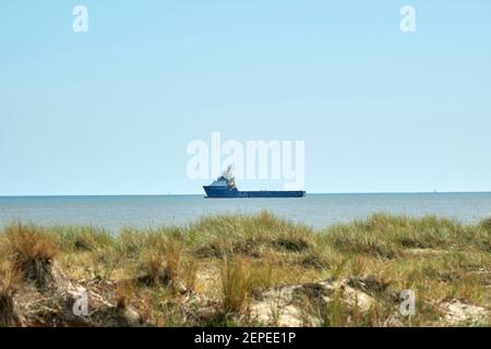 La barca parte dal porto esterno di Great Yarmouth. Da South Beach, guardando verso il mare, una barca di servizio lascia il porto. Foto Stock