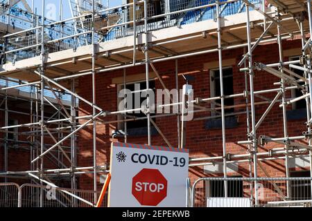 Shepshed, Leicestershire, Regno Unito. 27 febbraio 2021. Un cartello di avvertimento covid-19 si trova all'ingresso di un nuovo sviluppo di alloggi. Un sistema di garanzia ipotecaria per aiutare le persone con piccoli depositi ottenere sulla scala della proprietà è impostato per essere annunciato al bilancio della prossima settimana. Credit Darren Staples/Alamy Live News. Foto Stock