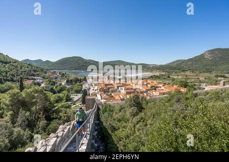 Ston, Croazia - 20 agosto 2020: Passeggiata turistica sulla stretta strada di pietra sul muro di Ston in estate mattina Foto Stock