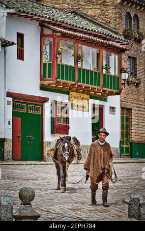 Horse, con contadino colombiano tradizionale poncho, ruana, Hat.500 year old Town.Colonial, Plaza de Bolívar, Tunja, Boyaca, Colombia Andes, America del Sud Foto Stock