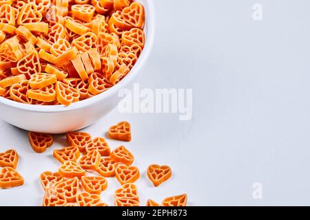 Pasta a forma di cuore in ciotola bianca Foto Stock