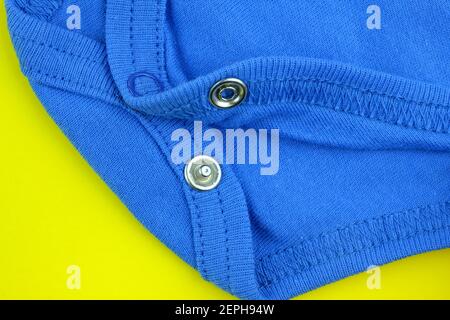 Primo piano di tessuto di cotone con rivetti. Accessori per abbigliamento per bambini. Pulsanti per la tuta per bambini. Abbigliamento per bambini. Foto Stock