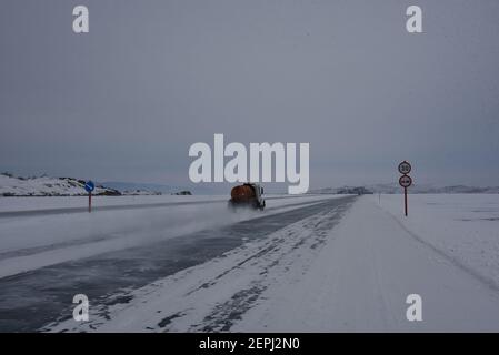 Olchon, Russia. 25 Feb 2021. Le auto guidano su uno strato di ghiaccio spesso un metro del lago Baikal all'isola di Olkhon. Un segnale stradale indica che il limite di velocità sul ghiaccio sul lato ovest del lago è 30. Credit: Ulf Maider/dpa/Alamy Live News Foto Stock