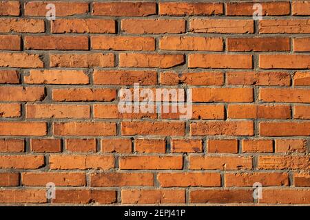 Sfondo rosso mattone vintage. Superficie ruvida resistente agli agenti atmosferici. Parte dell'esterno dell'edificio Foto Stock