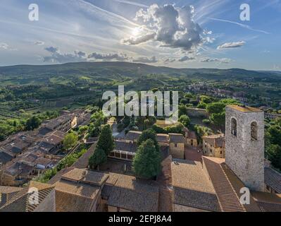 Paesaggio tipico con colline ondulate e vigneti intorno alla città di San Gimignano, un punto di riferimento nella regione vinicola famosa per le sue numerose torri in pietra e la chiesa Foto Stock