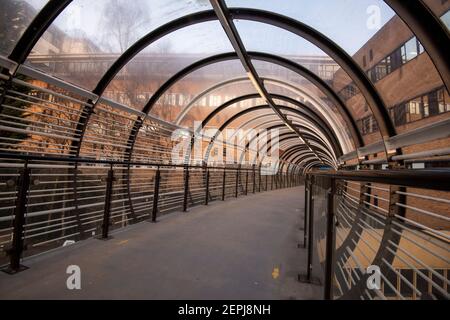 Luce mattutina sul ponte del tram Sir Peter Mansfield presso il Queens Medical Center (QMC) a Nottingham, Nottinghamshire, Inghilterra, Regno Unito Foto Stock