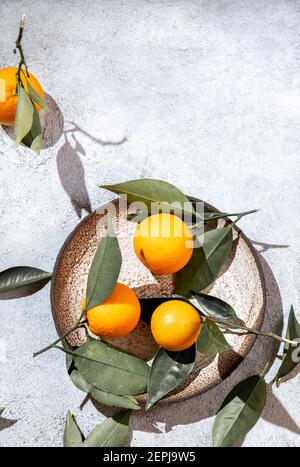 Arance intere con foglie di arance in piatto grigio. Su sfondo bianco vista dall'alto, piatto, estate e sano concetto. Foto Stock