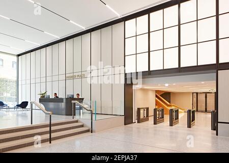 Lobby con ricchi posti a sedere in pelle marrone, grandi pannelli luminosi e banco ricevimento scultoreo. Premier Place, City of London, Regno Unito. Architetto: STI Foto Stock