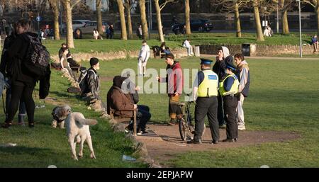 Brighton UK 27 Febbraio 2021 - gli ufficiali di supporto della Comunità di polizia controllano oggi le persone che si riuniscono nel parco di livello nel centro della città di Brighton mentre le restrizioni di blocco continuano in Inghilterra: Credit Simon Dack / Alamy Live News Foto Stock