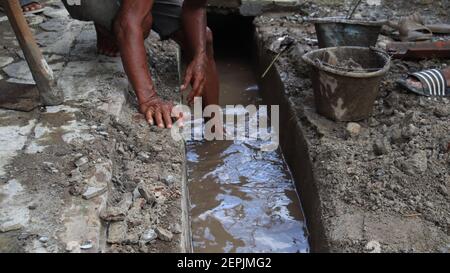 Immagine di messa a fuoco selettiva, gli operatori liberano le fogne dai rifiuti ostruiti Foto Stock