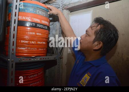 Tangerang, Indonesia. 27 Feb 2021. Un uomo di membro la comunità indonesiana di Layar Tancap Indonesia ha scelto un rotolo di film in una zona a Tangerang Sud, Indonesia, il 27 febbraio 2021. (Foto di Rahmat Dian Prasanto/INA Photo Agency/Sipa USA) Credit: Sipa USA/Alamy Live News Foto Stock