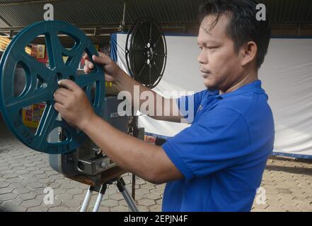 Tangerang, Indonesia. 27 Feb 2021. Un uomo della comunità indonesiana di Layar Tancap Indonesia ha installato il proiettore cinematografico in un'area a South Tangerang, Indonesia, il 27 febbraio 2021. (Foto di Rahmat Dian Prasanto/INA Photo Agency/Sipa USA) Credit: Sipa USA/Alamy Live News Foto Stock