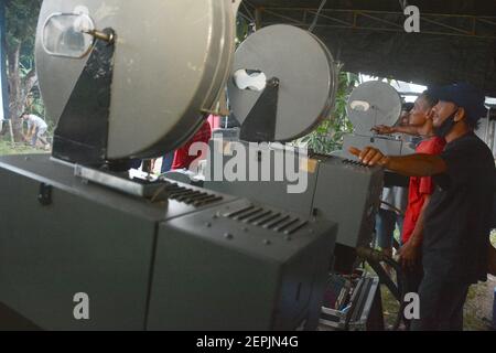 Tangerang, Indonesia. 27 Feb 2021. Un uomo della comunità indonesiana di Layar Tancap Indonesia ha installato il proiettore cinematografico in un'area a South Tangerang, Indonesia, il 27 febbraio 2021. (Foto di Rahmat Dian Prasanto/INA Photo Agency/Sipa USA) Credit: Sipa USA/Alamy Live News Foto Stock