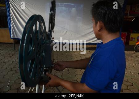 Tangerang, Indonesia. 27 Feb 2021. Un uomo della comunità indonesiana di Layar Tancap Indonesia ha installato il proiettore cinematografico in un'area a South Tangerang, Indonesia, il 27 febbraio 2021. (Foto di Rahmat Dian Prasanto/INA Photo Agency/Sipa USA) Credit: Sipa USA/Alamy Live News Foto Stock