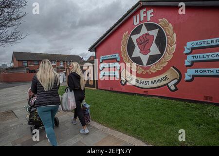 BELFAST, IRLANDA DEL NORD - Febbraio, 24: Due donne camminano oltre i murales Loyalist a 'Freedom Corner', Newtownards Road, Belfast.pricipalmente lavorante-class Pro Foto Stock