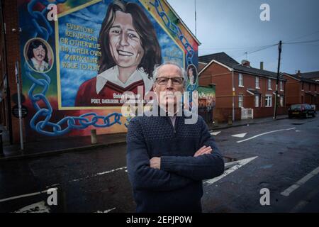 BELFAST, IRLANDA DEL NORD - Febbraio, 23 Gerry Kelly di fronte al murale di Bobby Sands presso la sede centrale del Sinn Fein riceve una chiamata per l'allerta contro la bomba Foto Stock