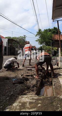 Lavoratori che sgomberano le fogne dai rifiuti intasati, Pekalongan, 26 febbraio 2021 Foto Stock