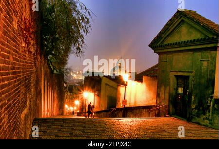 Le luci della strada illuminano la sera sui gradini che conducono Giù dalla cattedrale di praga alla vecchia Praga Foto Stock