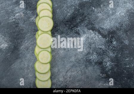 Fette di zucchine fresche in linea su sfondo grigio Foto Stock