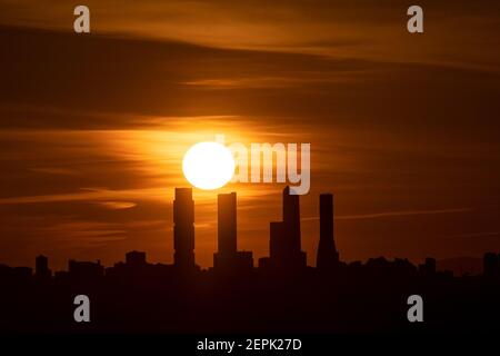 Madrid, Spagna. 27 Feb 2021. Il sole tramonta con la vista dello skyline della Four Towers Business Area (CTBA) durante un pomeriggio di primavera con il tempo caldo. Credit: Marcos del Mazo/Alamy Live News Foto Stock