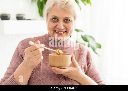 donna anziana miele a casa, stile di vita concetto Foto Stock