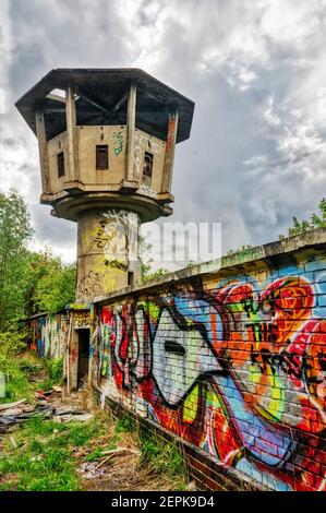 Una torre di guardia abbandonata e coperta di graffiti a Berlino, in Germania Foto Stock