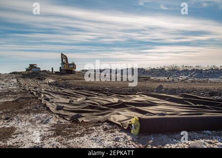 Tessuto geotessile arrotolato sulla ghiaia per proteggere il permafrost sotto l'autostrada Inuvik-Tuktoyaktuk, territori del Nord-Ovest, l'Artico del Canada. Foto Stock