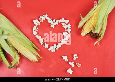 Due cornici e popcorn a forma di cuore su sfondo rosso Foto Stock