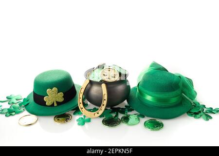 Buon giorno di San Patrizio. Sciamrocchi lucenti, monete d'oro e cappello leprechaun su backgorund bianco. Foto Stock