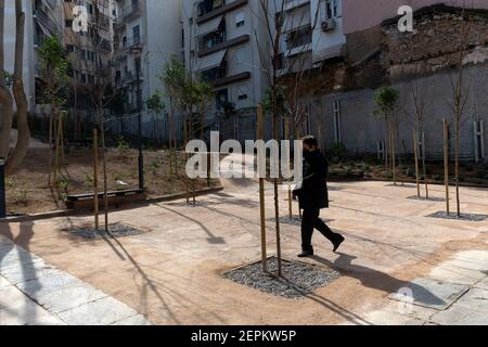 Atene, Grecia. 25 Feb 2021. Una donna cammina in un parco tascabile nel quartiere di Pagrati ad Atene, in Grecia, il 25 febbraio 2021. Il parco tascabile, che è stato creato in uno spazio abbandonato che è stato un terreno spazzatura per anni tra blocchi di appartamenti, è il terzo consegnato dalla città di Atene ultimamente, mentre almeno dieci sono allineati nei prossimi mesi. Credit: Marios Lolos/Xinhua/Alamy Live News Foto Stock