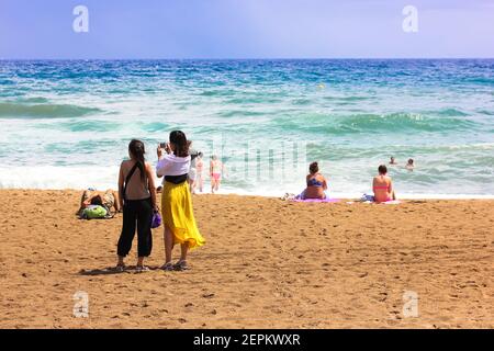 Le persone si sono riunite sulle rive del Mar Mediterraneo in estate per rilassarsi durante le vacanze estive. Le persone sono prendere il sole, nuotare e lookin Foto Stock