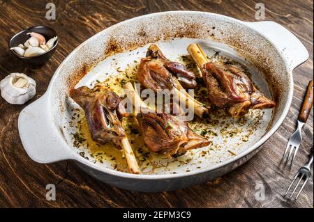 Agnello brasato fatto in casa in un piatto da forno. Sfondo di legno. Vista dall'alto Foto Stock