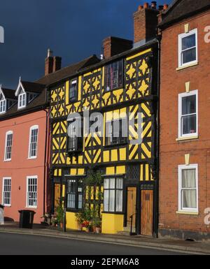 Yellow 17th Century Tudor-style casa con struttura in legno su Corve St, Ludlow, Shropshire, Inghilterra. Rinforzo Chevron al 1° piano. Controventatura del secondo Foto Stock