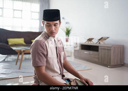 Ritratto di giovane musulmano asiatico che prega a casa Foto Stock