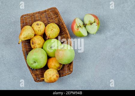 Mele e pere nel cestello su fondo grigio Foto Stock