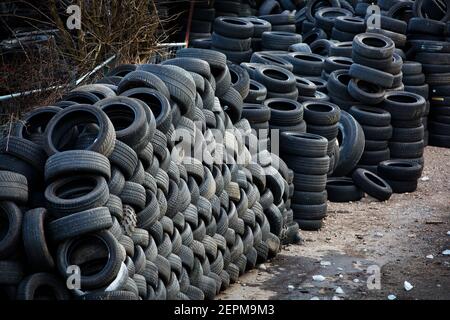 Vano portaoggetti per pneumatici usati . Smaltimento dei rifiuti pneumatici, pneumatici auto. Vano portaoggetti con scaffali alti di pneumatici per auto. Foto Stock