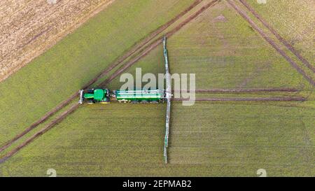 25 febbraio 2021, bassa Sassonia, Hanstedt i: Un agricoltore diffonde concime liquido su un campo con la sua squadra (sparato con un drone). Foto: Philipp Schulze/dpa Foto Stock