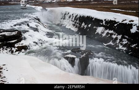 Acqua dalla cascata che spruzzi su un fiume roccioso Islanda Foto Stock