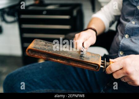 Barbiere maschile tagliato irriconoscibile con rasoio e pelle stroping affilatura strumento classico Foto Stock