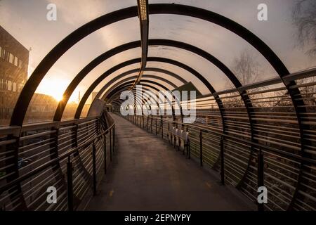 Luce mattutina sul ponte del tram Sir Peter Mansfield presso il Queens Medical Center (QMC) a Nottingham, Nottinghamshire, Inghilterra, Regno Unito Foto Stock