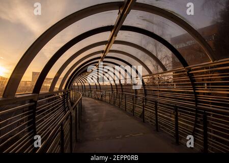 Luce mattutina sul ponte del tram Sir Peter Mansfield presso il Queens Medical Center (QMC) a Nottingham, Nottinghamshire, Inghilterra, Regno Unito Foto Stock