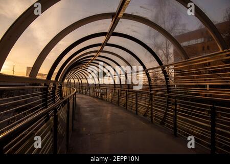 Luce mattutina sul ponte del tram Sir Peter Mansfield presso il Queens Medical Center (QMC) a Nottingham, Nottinghamshire, Inghilterra, Regno Unito Foto Stock