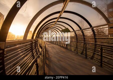 Luce mattutina sul ponte del tram Sir Peter Mansfield presso il Queens Medical Center (QMC) a Nottingham, Nottinghamshire, Inghilterra, Regno Unito Foto Stock