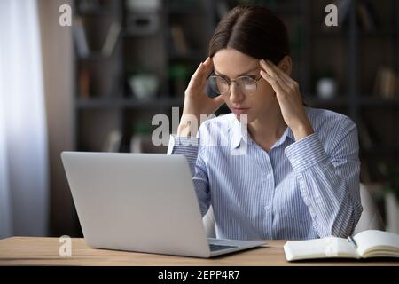 Donna infelice lavora su computer che ha problemi Foto Stock