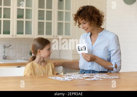 La madre felice insegna la matematica della figlia piccola del bambino usando le schede di flash Foto Stock