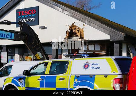 Dymchurch, Kent, Regno Unito. 28 febbraio 2021. I ladri immolati hanno tentato un’audace incursione su questo Tesco express in via Dymchurch Hugh avendo guidato un escavatore cingolato Volvo ECR235E nelle prime ore del mattino in una tentata rapina da cashpoint. Un negozio di fronte è stato lasciato con 'danno significativo' in un tentativo fallito di strappare una macchina di cassa con un digger, la polizia dice. Un angolo dell'edificio si trova in tatters. Si credeva che il digger fosse stato rubato da Dymchurch Beach. Photo Credit: Paul Lawrenson/Alamy Live News Foto Stock
