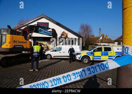 Dymchurch, Kent, Regno Unito. 28 febbraio 2021. I ladri immolati hanno tentato un audace raid di ariete su questo Tesco express in via Dymchurch Hugh avendo guidato un escavatore cingolato Volvo ECR235E nelle prime ore del mattino in una tentata rapina da cashpoint. Un negozio di fronte è stato lasciato con 'danno significativo' in un tentativo fallito di strappare una macchina di cassa con un digger, la polizia dice. Un angolo dell'edificio si trova in tatters. Si credeva che il digger fosse stato rubato da Dymchurch Beach. Photo Credit: Paul Lawrenson/Alamy Live News Foto Stock