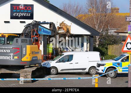 Dymchurch, Kent, Regno Unito. 28 febbraio 2021. I ladri immolati hanno tentato un audace raid di ariete su questo Tesco express in via Dymchurch Hugh avendo guidato un escavatore cingolato Volvo ECR235E nelle prime ore del mattino in una tentata rapina da cashpoint. Un negozio di fronte è stato lasciato con 'danno significativo' in un tentativo fallito di strappare una macchina di cassa con un digger, la polizia dice. Un angolo dell'edificio si trova in tatters. Si credeva che il digger fosse stato rubato da Dymchurch Beach. Photo Credit: Paul Lawrenson/Alamy Live News Foto Stock