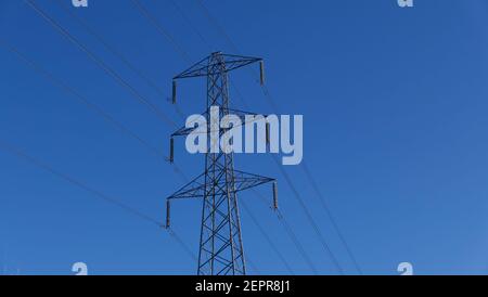 Pilone elettrico contro il cielo blu profondo con spazio per copt Foto Stock